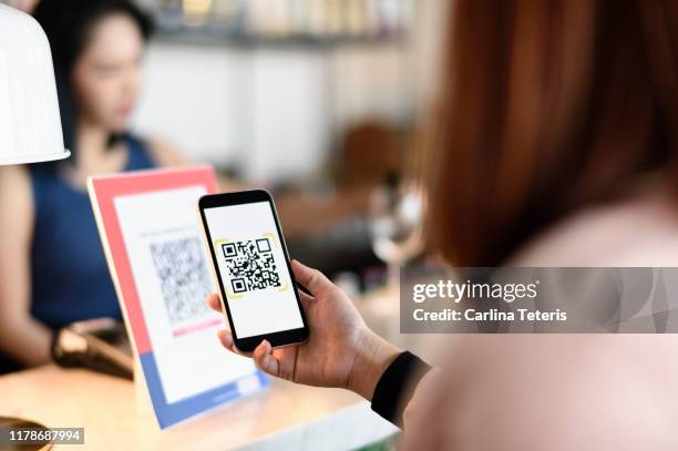 woman making a qr code payment in a bar - qr code image stock pictures, royalty-free photos & images