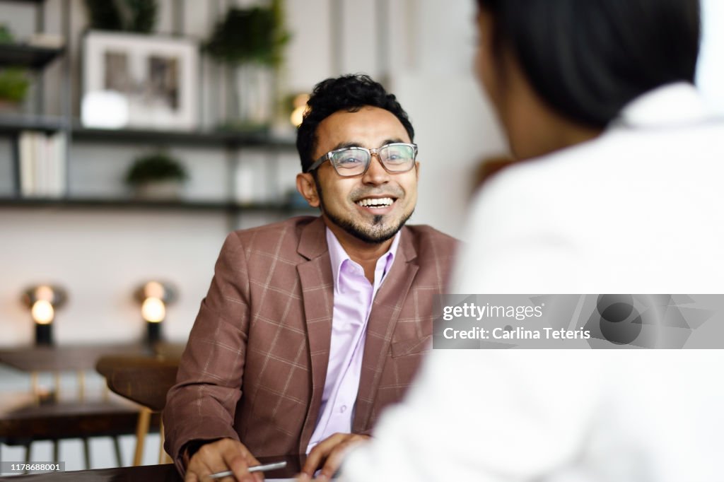 Malay man signing papers at a business meeting