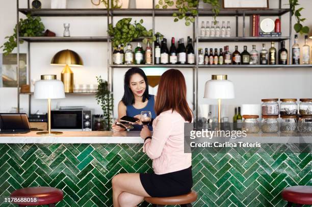 Busineses woman making contactless payment in a modern bar