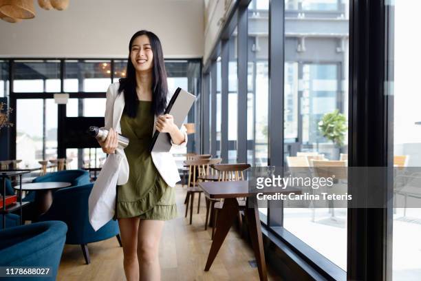 Business woman walking into work with computer and water bottle