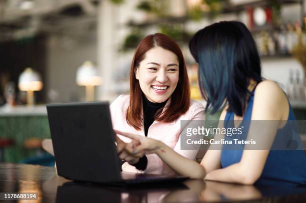 woman mentoring her young colleague - mentor stock-fotos und bilder