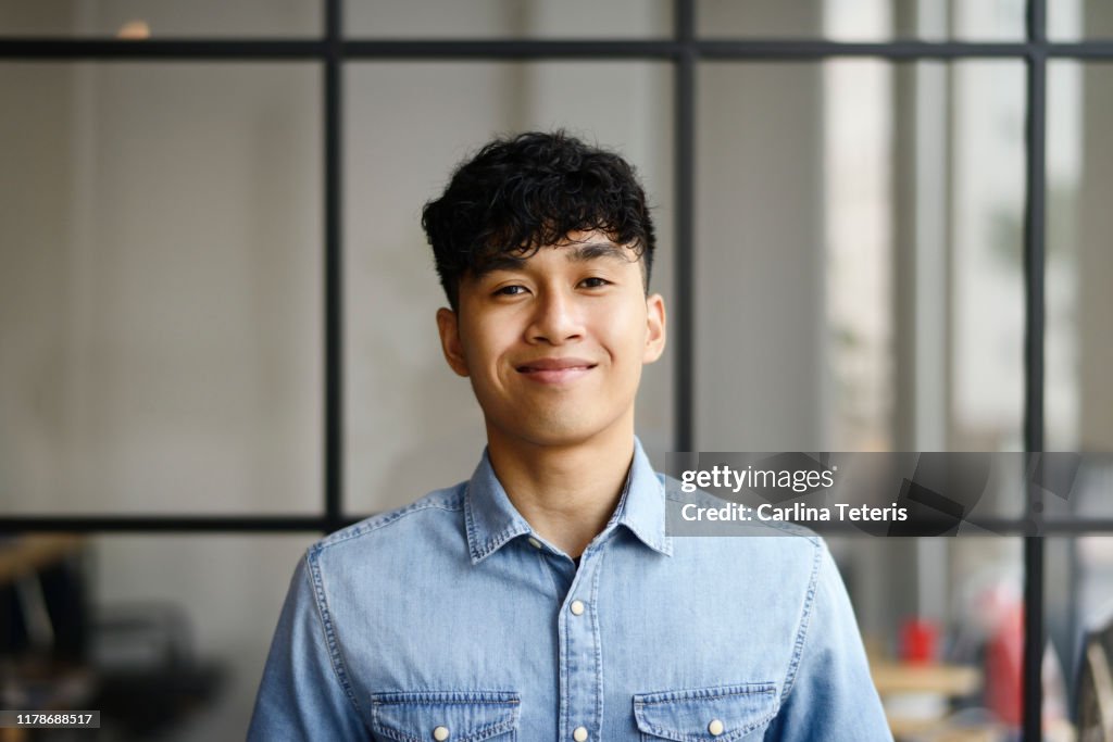Portrait of a young Malay man in a modern office