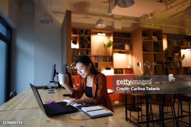 Young Chinese woman working on her laptop late at night