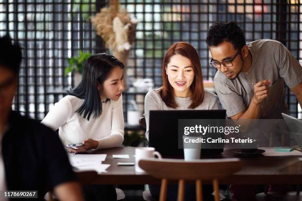 group of singaporeans working in a co-working office - young muslim man stockfoto's en -beelden
