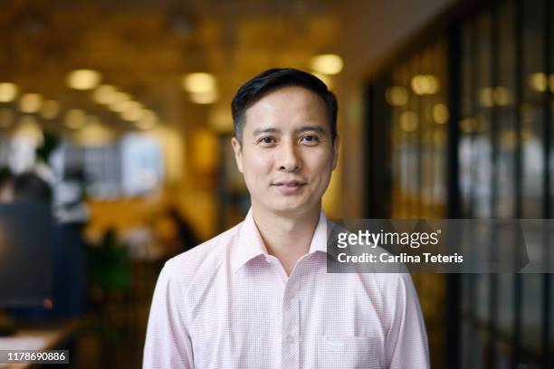 portrait of a chinese business man in an office - chinese ethnicity stock pictures, royalty-free photos & images