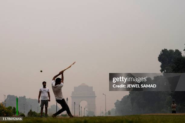 Youths play cricket in a park near India Gate under heavy smog in New Delhi on October 29, 2019.