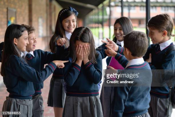 kinderen pesten een meisje op de school - pest stockfoto's en -beelden