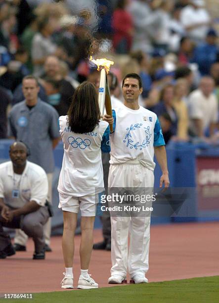 Tom Cruise hands off Olympic flame to Janet Evans during 2004 Olympic Torch Relay Celebration at Dodger Stadium on Wednesday, June 16, 2004.