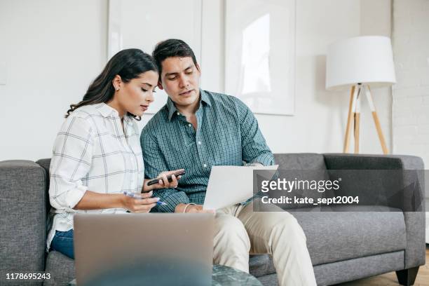 pareja mirando estados de cuenta bancarios - insurance fotografías e imágenes de stock