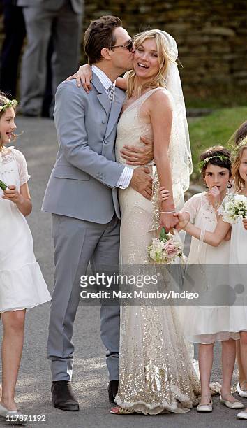 Jamie Hince and Kate Moss kiss as they leave St. Peter's Church after their wedding on July 1, 2011 in Southrop, England.