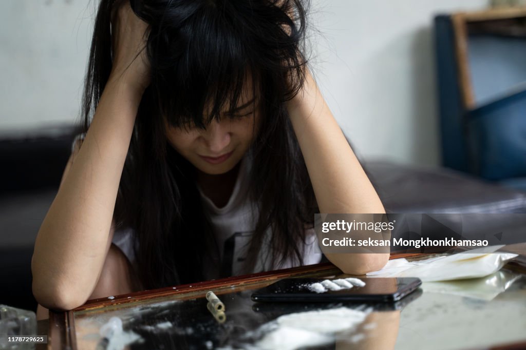 The drug addicts cry on the drug background. Addicted women who have smeared makeup near the cocaine line,