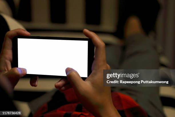 hands holding smartphone with blank screen and playing game - horisontell bildbanksfoton och bilder