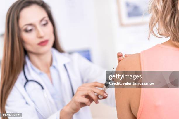 female doctor vaccinating a patient - yellow fever stock pictures, royalty-free photos & images