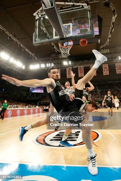 Chris Goulding of United fouls Ben Madgen of the Phoenix as he drives to the basket during the round one NBL match between Melbourne United and the...