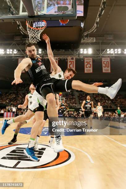 Chris Goulding of United fouls Ben Madgen of the Phoenix as he drives to the basket during the round one NBL match between Melbourne United and the...