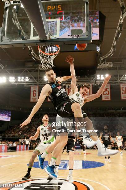 Chris Goulding of United fouls Ben Madgen of the Phoenix as he drives to the basket during the round one NBL match between Melbourne United and the...