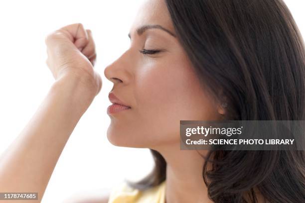 woman smelling perfume on her wrist - odorat photos et images de collection