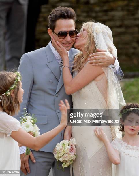 Jamie Hince and Kate Moss kiss as they leave St. Peter's Church after their wedding on July 1, 2011 in Southrop, England.