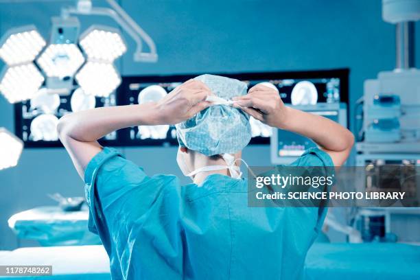 surgeon gowning up - operating theatre uk stock pictures, royalty-free photos & images