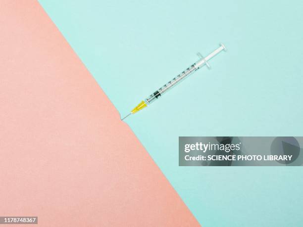 syringe piercing skin, conceptual image - syringe stock-fotos und bilder