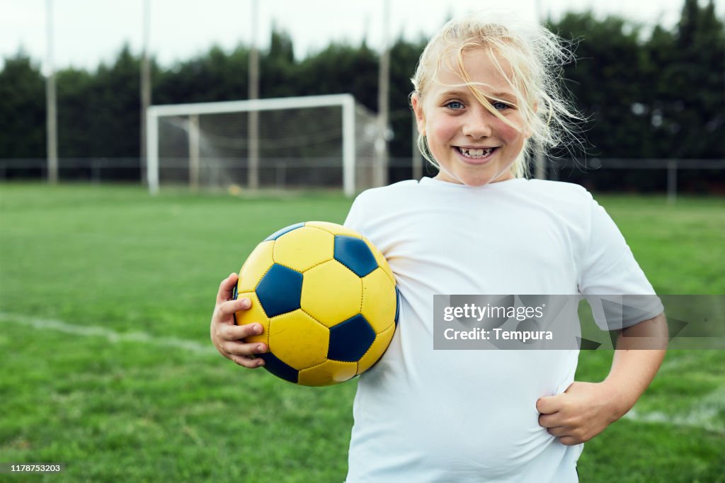 Eight years old soccer player portrait looking at camera.