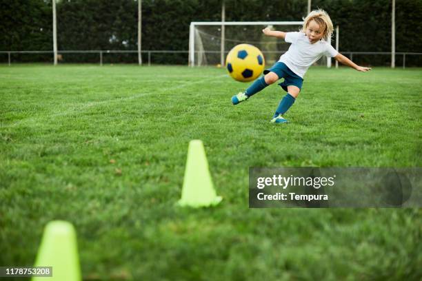 los niños pequeños disparan una volea de fútbol perfecta. - tiro a portería fotografías e imágenes de stock