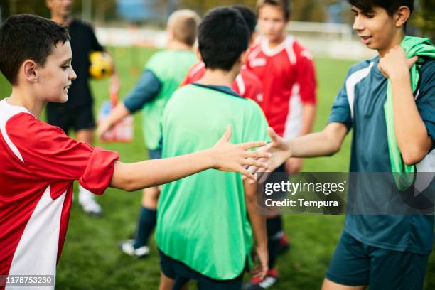 two teenage soccer players greet each other after the match. - competition round imagens e fotografias de stock