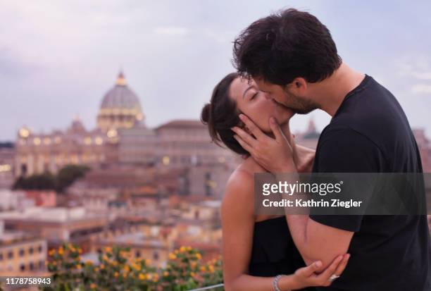 beautiful couple kissing on roman rooftop terrace, st. peter's basilica in background - basílica de são pedro - fotografias e filmes do acervo