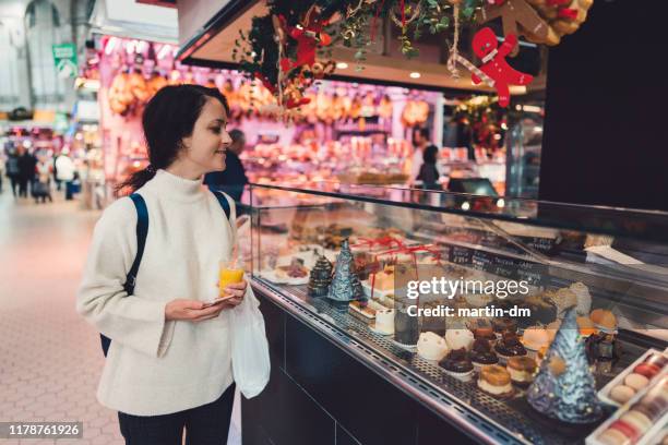 frau genießt die kuchenthekaufausstellung auf dem bauernmarkt - bakery display stock-fotos und bilder