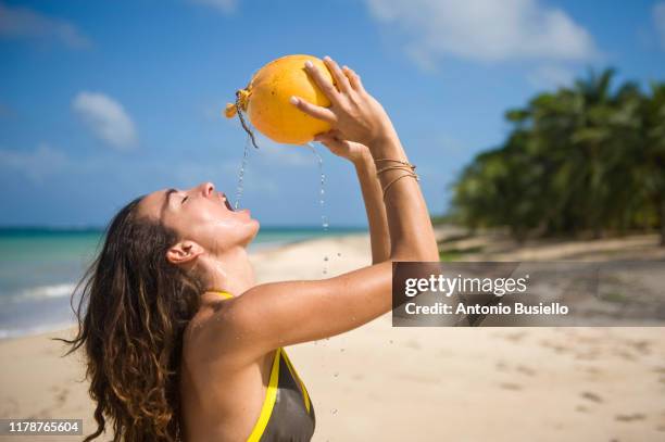 women drinking from coconut - coconut beach woman stock pictures, royalty-free photos & images