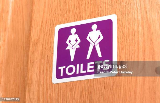 gender neutral desperate for the toilet, illustrated on door sign - irritable bowel syndrome stock pictures, royalty-free photos & images