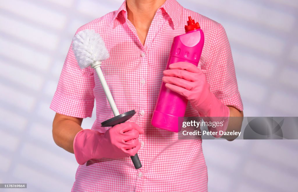Cleaner holding toilet brush and bleach