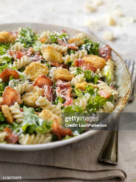 kale and romaine pasta caesar salad - pasta salad stock pictures, royalty-free photos & images