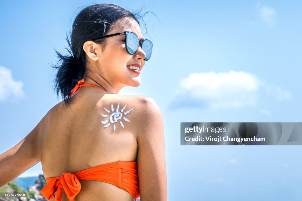 Young woman with sun cream shape on shoulder, Sun protection sun cream.