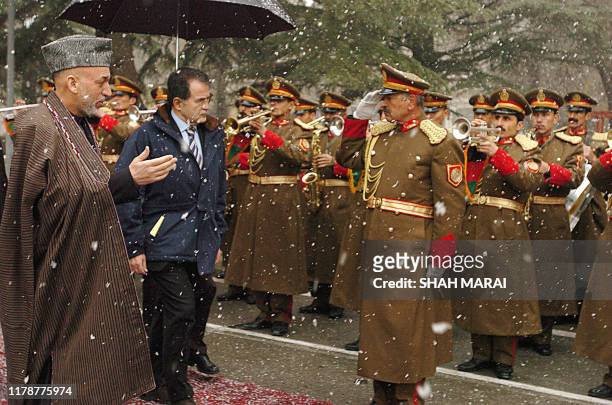 Afghan President Hamid Karzai and Italian Prime Minister Romano Prodi inspect a guard of honour in the falling snow prior to a meeting at the...