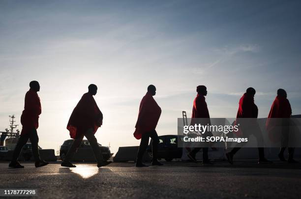 Sub-Saharan migrants walk toward a humanitarian emergency stall on arrival at the Port of Malaga. A total of 61 migrants were rescued from a dinghy...
