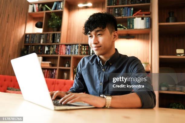 young asian is working on laptop in the library - blog news stock pictures, royalty-free photos & images