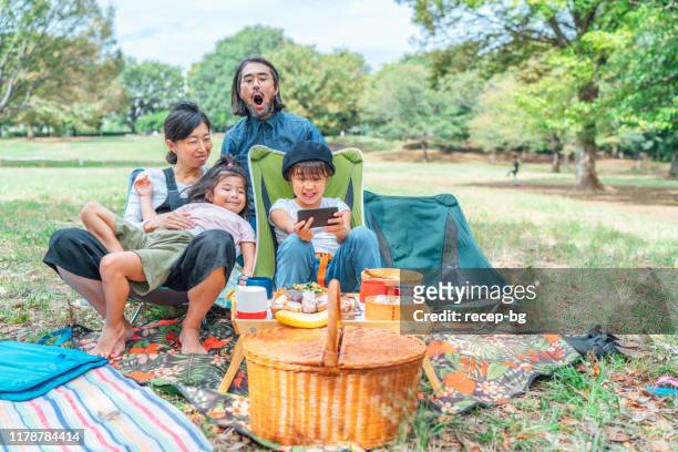 公共の公園でビーガンピクニックを持ち、自分撮りをする家族 - family at a picnic ストックフォトと画像
