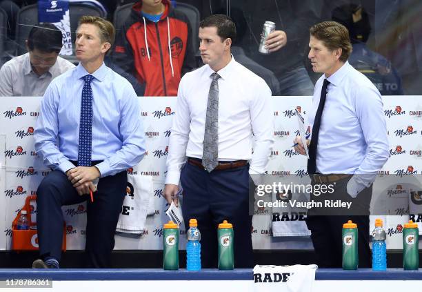 Assistant Coaches Dave Hakstol, Paul McFarland and Head Coach Mike Babcock of the Toronto Maple Leafs look on from the bench prior to an NHL game...