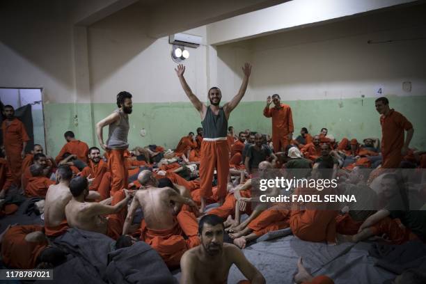 Men, suspected of being affiliated with the Islamic State group, gather in a prison cell in the northeastern Syrian city of Hasakeh on October 26,...