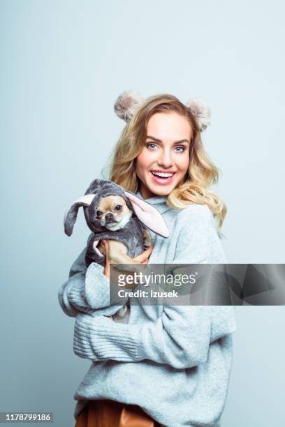 winterporträt von überrascht schöne frau hält chihuahua - woman holding dog studio stock-fotos und bilder
