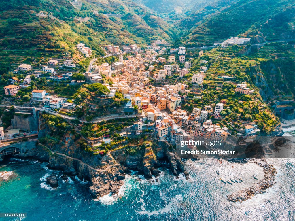 Ciudad en montañas que se elevan sobre el mar tranquilo, Cinque Terre, Italia