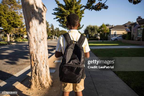 afro american kid coming back from school - coming back stock pictures, royalty-free photos & images