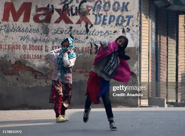 Female protesters throw stones during clashes with Indian police in Srinagar,Kashmir on October 29, 2019. Protest and clashes were reported from many...