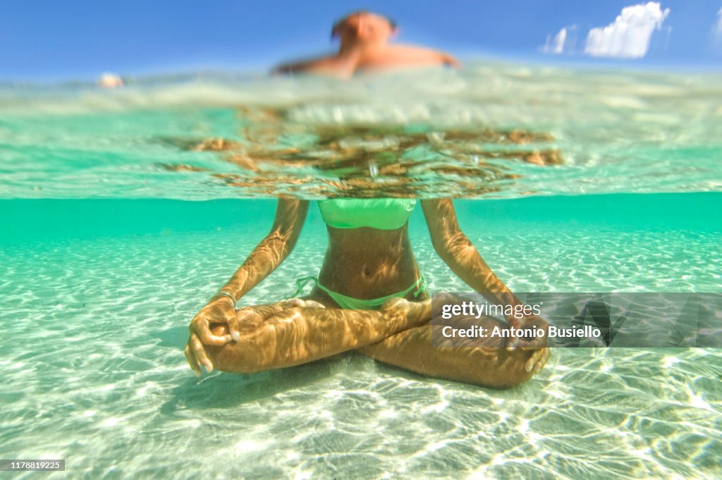 Young woman doing yoga in the water