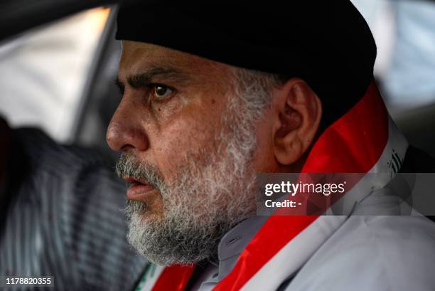 Iraqi Shiite cleric Moqtada al-Sadr drives a car as he joins anti-government demonstrators gathering in the central holy city of Najaf on October 29,...