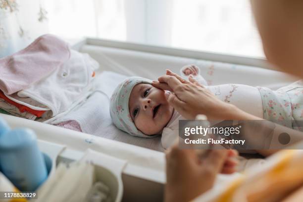mother caring after her baby's skin - baby goods stock pictures, royalty-free photos & images