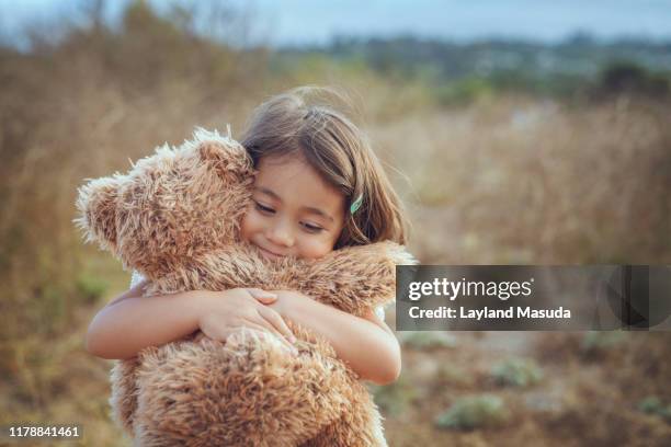 teddy bear hugs with happy 3 years girl - child teddy bear stock-fotos und bilder