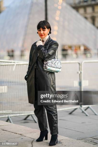 Maria Bernad wears earrings, a black leather coat, a white lace mesh top, pearl earrings, black pants, black shoes, outside Louis Vuitton, during...