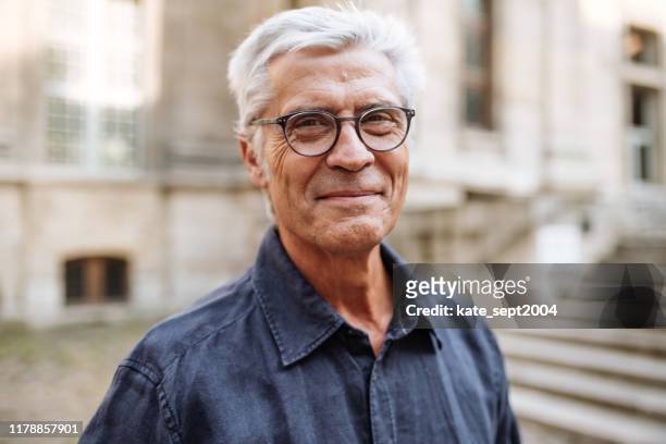 straat portret van lachende senior man - pensioen thema stockfoto's en -beelden